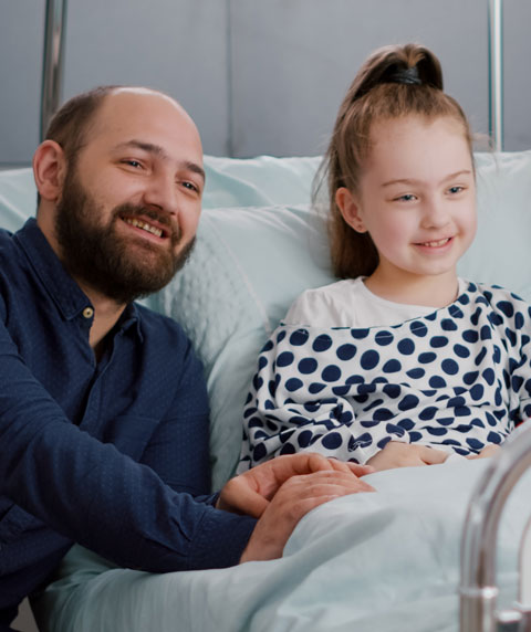 un homme et sa petite fille qui est dans un lit d'hôpital